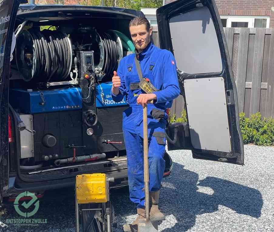 Een tevreden monteur met opgestoken duim naast de bestelbus, slim ingrijpen bespaart kosten bij een verstopte afvoer in Zwolle
