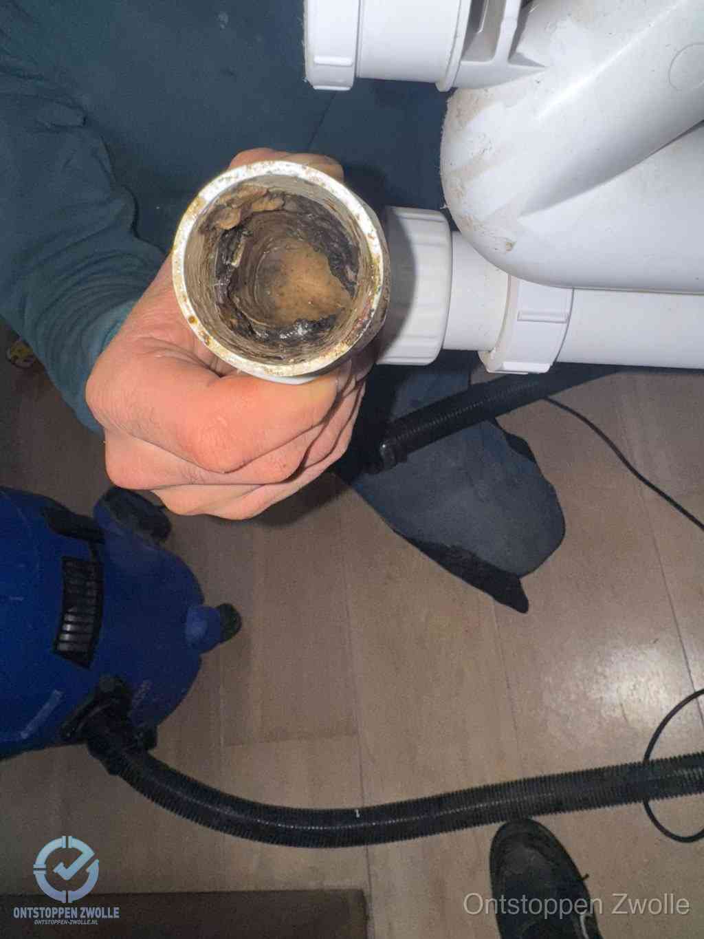Een losgekoppeld afvoerbuisstuk dat van binnen volledig is dichtgeslibd, het gevolg van een verstopping te lang laten zitten in Zwolle