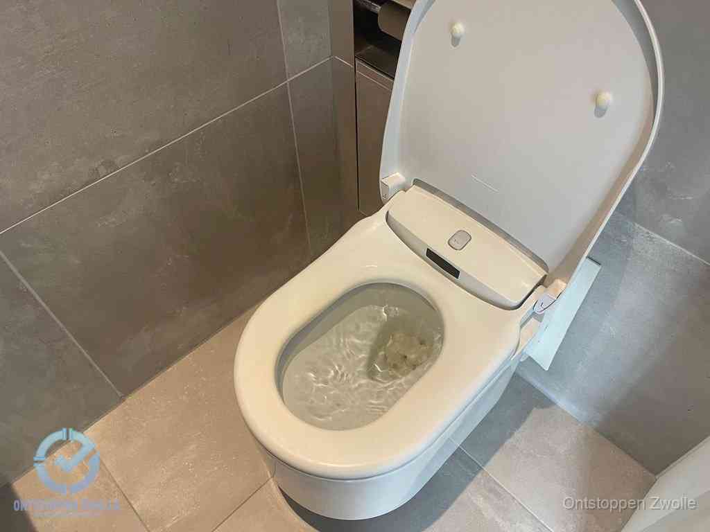 Een toiletpot vol troebel water met drijvend papier en restanten, de meest voorkomende oorzaak van een verstopte wc in Zwolle
