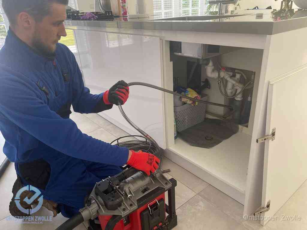 Een monteur reinigt de keukenafvoer grondig met een veermachine om terugkerende gootsteenverstoppingen te voorkomen in Zwolle